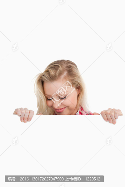 快樂的金發(fā)女人看著一個空白的標(biāo)志