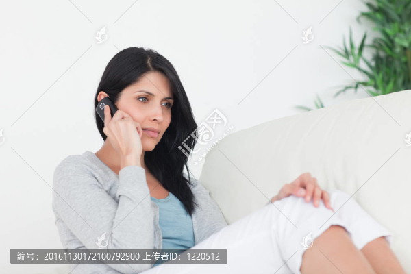 女人打電話，坐在沙發(fā)上