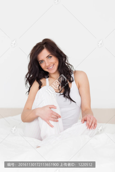 微笑的黑發(fā)女人坐在她的床上