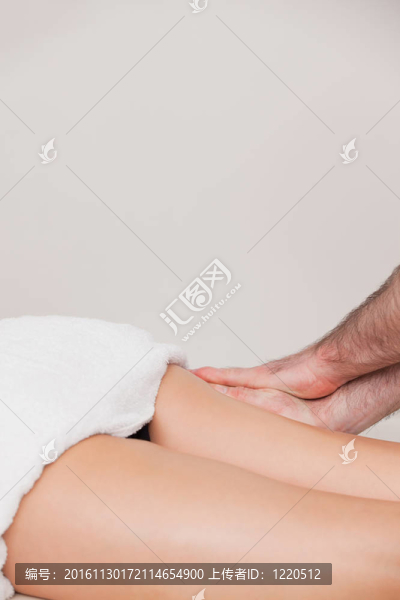 女人按摩她的大腿的按摩師