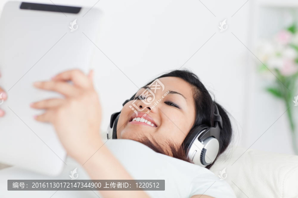 面帶微笑的女人躺在一輛馬車上，戴著耳機(jī)