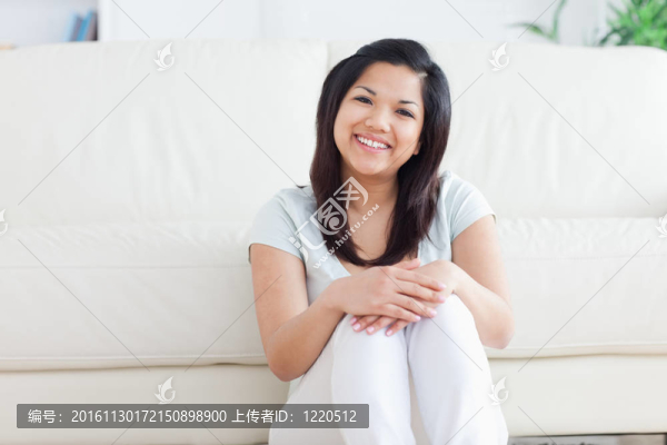 女人坐在客廳的地板上微笑