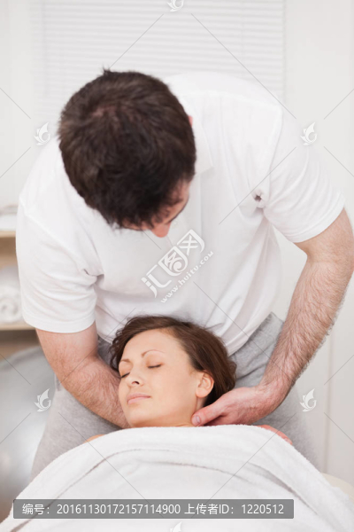 治療師按摩女人的脖子，抱著她的頭