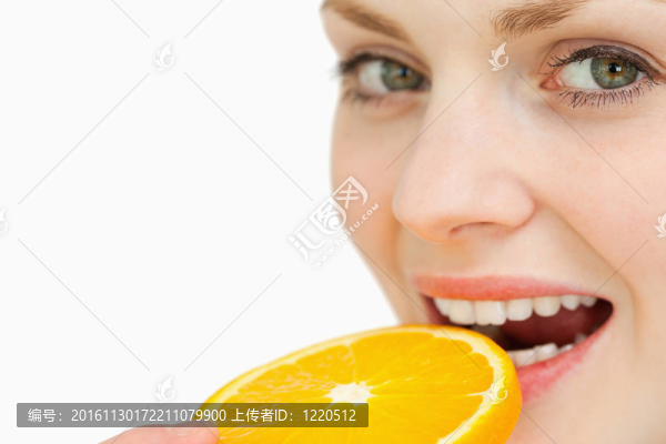 一個女人把一片桔子放進嘴里
