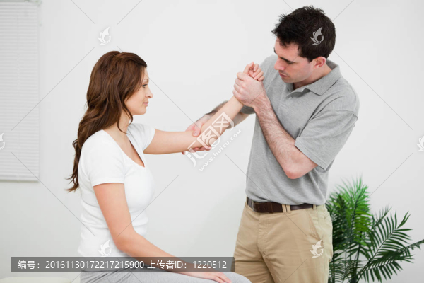 嚴(yán)肅的醫(yī)生觸摸女人的手肘