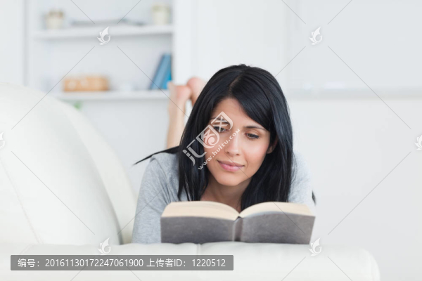 躺在沙發(fā)上看書的女人