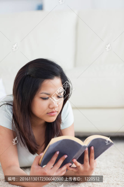 女人躺在地板上看書