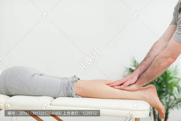 靠近一個按摩師按摩女人的小腿