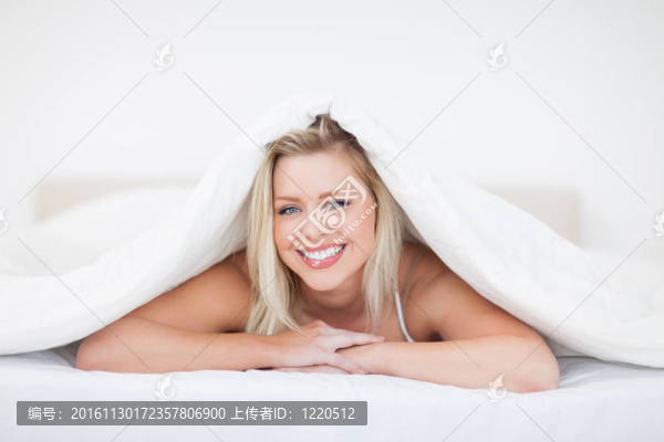 年輕的金發(fā)女子躺在鴨絨被