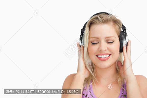 快樂的金發(fā)女人用耳機聽音樂