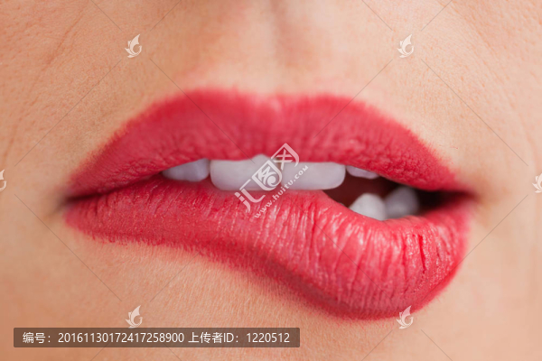 迷人的女人咬著她美麗的嘴唇