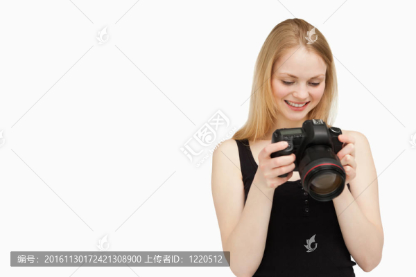 快樂(lè)的女人看著她的相機(jī)