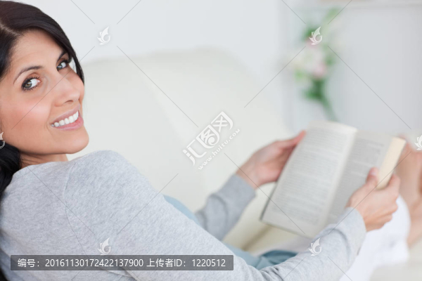女人躺在沙發(fā)上拿著一本書(shū)