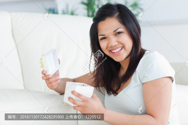 女人手里拿著一個打開的禮物盒微笑