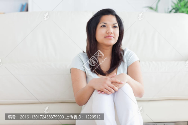 女人坐在沙發(fā)前的地板上微笑