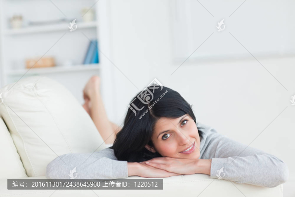 女人在沙發(fā)上休息，把頭靠在胳膊上