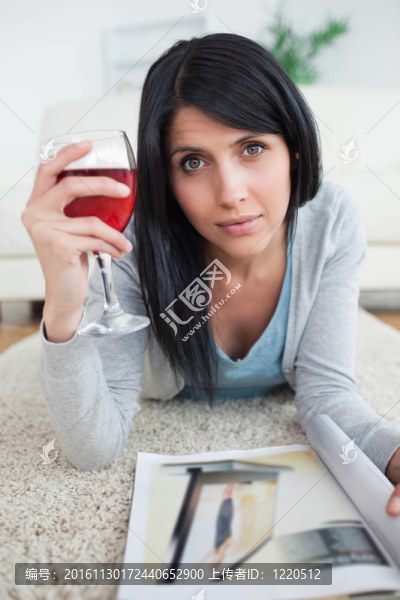 女人拿著一杯紅酒拿著一本雜志