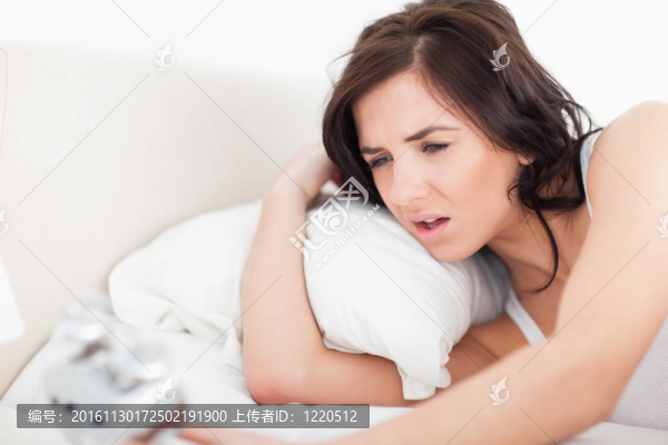 黑發(fā)女子醒來(lái)看著她的鬧鐘