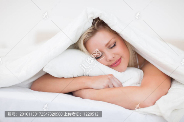金發(fā)女郎一邊抱著枕頭一邊休息