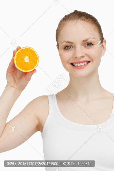 微笑的女人握著一個橘子