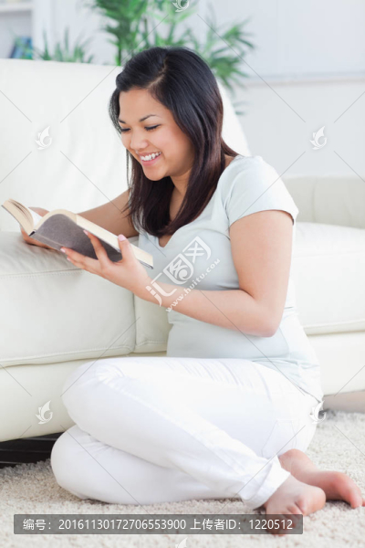 女人坐在白色沙發(fā)上看書