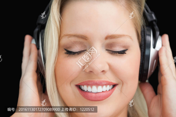 歡快的女人在聽音樂時閉上眼睛