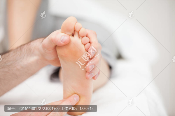 醫(yī)生用指尖觸摸一只腳的球