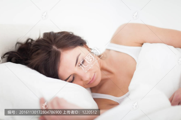 黑發(fā)女子躺在一張床上睡覺