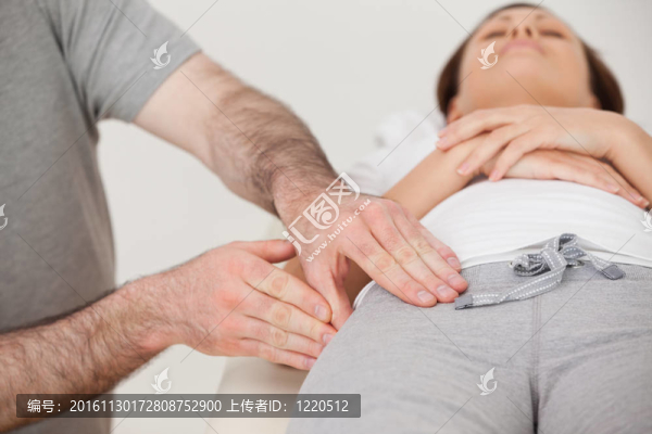 女子躺在一個理療按摩她的大腿