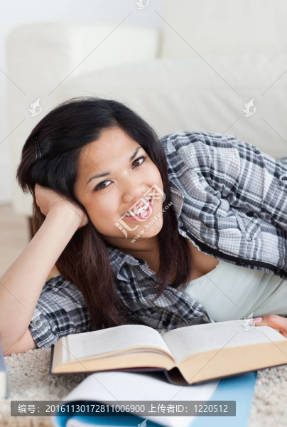 一個(gè)面帶微笑的女人手里拿著一本書(shū)