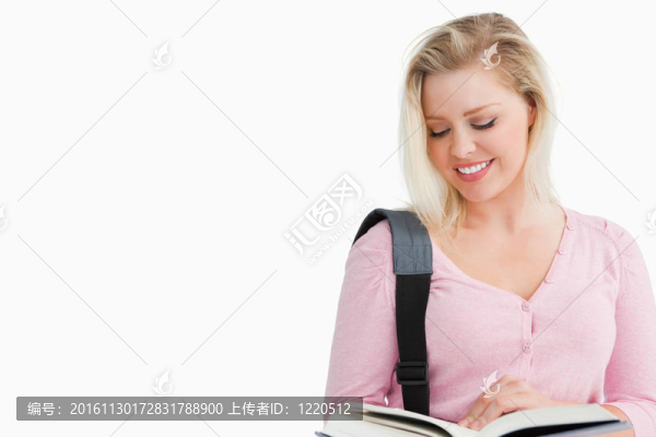微笑的金發(fā)女人讀一本有趣的小說