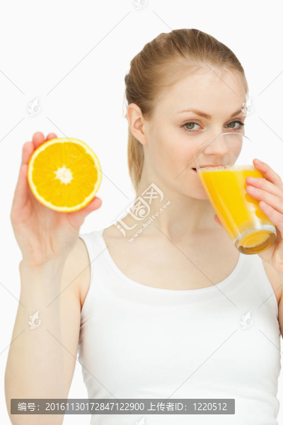 女人在杯子里喝著橘子