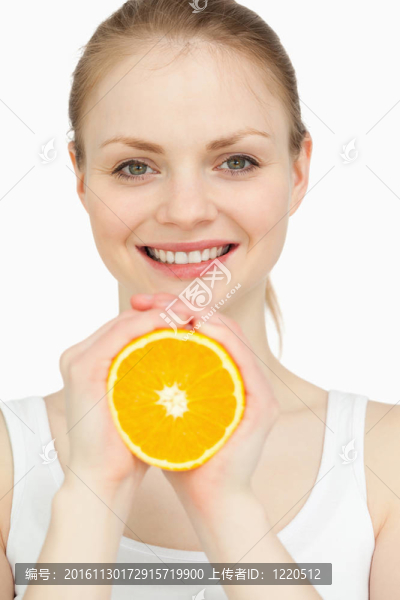 微笑的女人手里拿著一個橘子