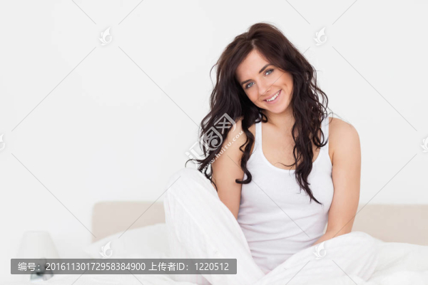 開朗的黑發(fā)女人坐在她的床上