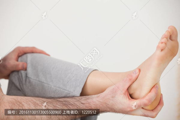按摩師拿著一個病人腳跟