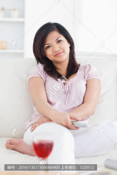 婦女抱著電視遙控器，一邊交叉雙臂
