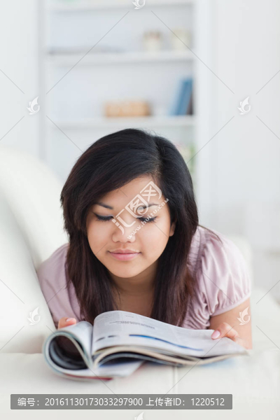 在沙發(fā)上休息的婦女拿著一本雜志