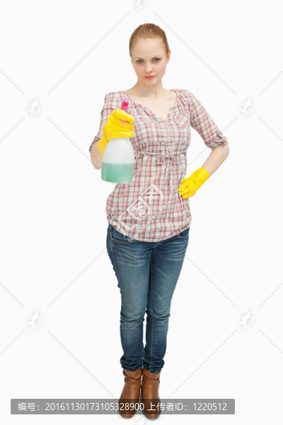 抱著噴霧瓶的女人站著