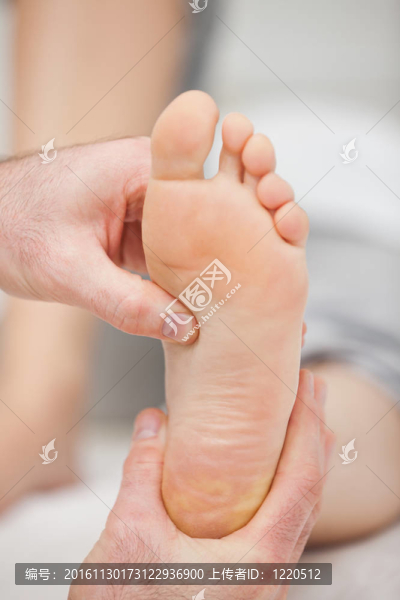 醫(yī)生用拇指壓腳底