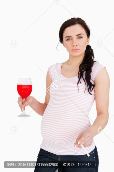 懷孕的年輕婦女拿著酒精飲料和香煙