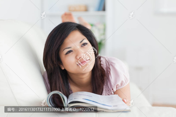 女人躺在沙發(fā)上看雜志