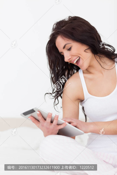 快樂(lè)的女人拿著她的平板電腦坐著