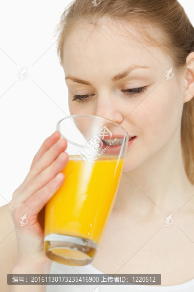 女人一邊喝著橙汁一邊看著它