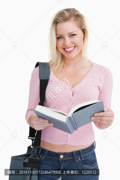 快樂(lè)的金發(fā)女人拿著一本小說(shuō)和她的雙肩包