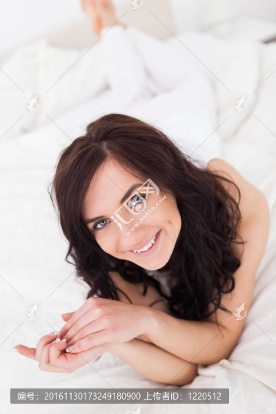 幸福的棕色頭發(fā)女人躺在毯子上