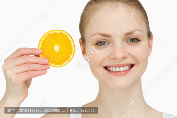 快樂的女人拿著一片橘子