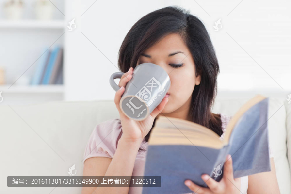 拿著書喝著杯子的女人
