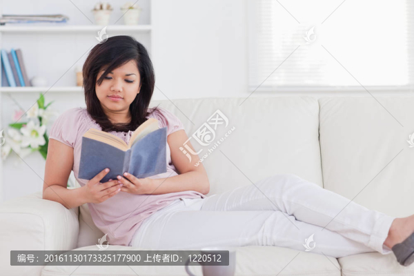 躺在沙發(fā)上看書的女人