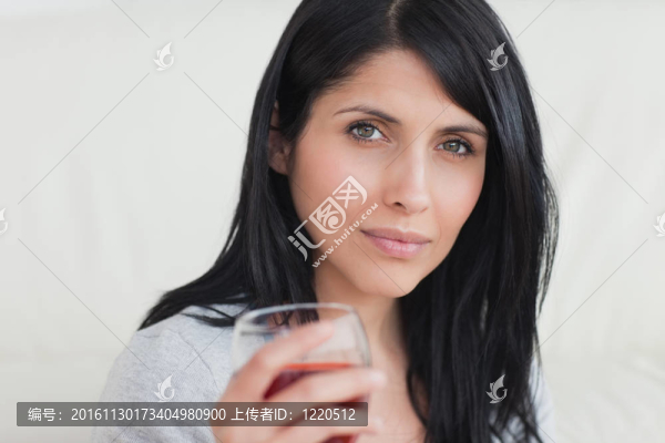 女人拿著一杯滿是紅葡萄酒的杯子