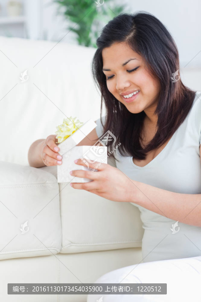 女子打開禮品盒，站在她的膝蓋前